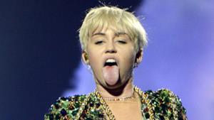 MIley Cyrus con lingua di fuori e capelli scompigliati