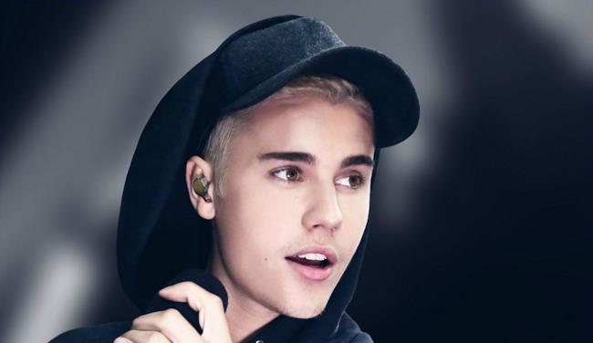Justin Bieber biondo con cappello e felpa nera