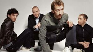 I componenti dei Coldplay seduti per terra