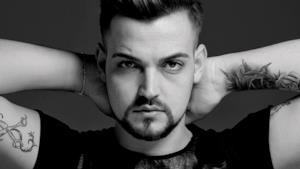 Valerio Scanu in bianco e nero con le mani dietro la testa