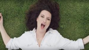 Laura Pausini stesa sull'erba nel video di Simili
