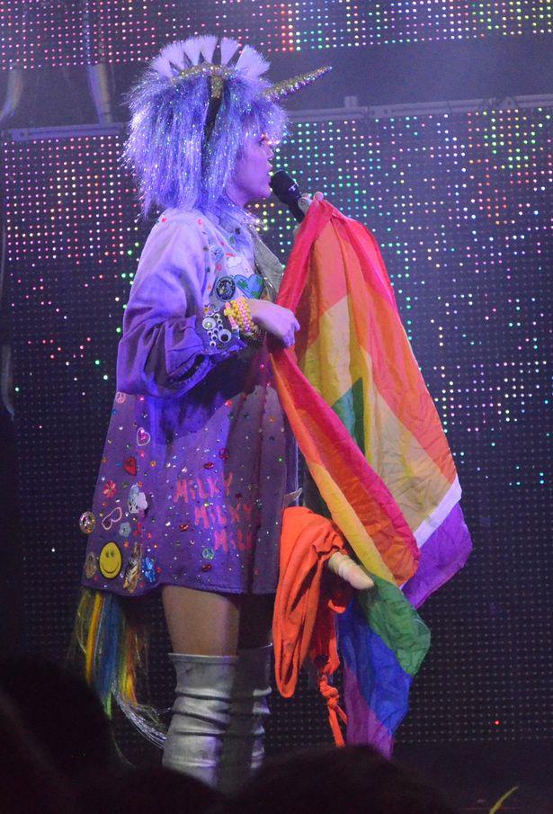 Miley Cyrus è un unicorno porno con pene finto e bandiera multicolore