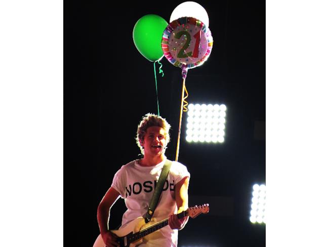 Niall Horan con chitarra e palloncini durante un concerto