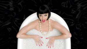 Katy Perry nella vasca da bagno con caschetto nero e unghie rosse