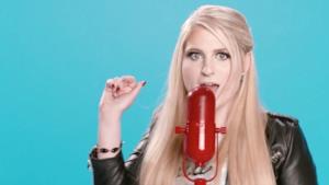 Meghan Trainor davanti a un microfono rosso