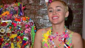 Miley Cyrus di fianco alla sua opera d'arte multicolor