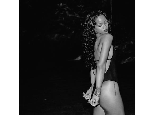 Rihanna in costume nero inquadrata lateralmente