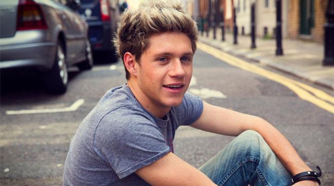 Niall Horan seduto per terra in strada