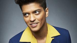 Bruno Mars in giacca blu e camicia gialla