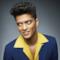 Bruno Mars in giacca blu e camicia gialla