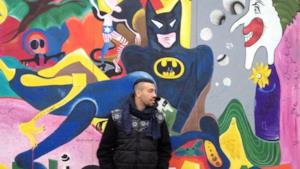 Mondo Marcio con alle spalle il muro di Berlino