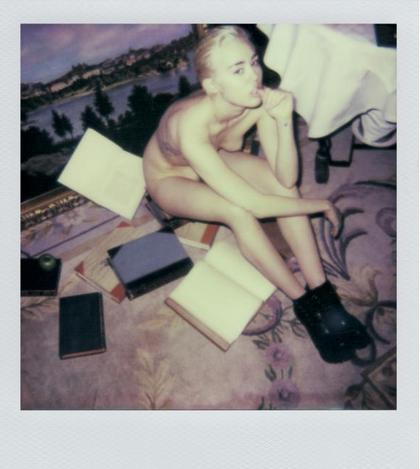 Miley Cyrus seduta nuda per terra