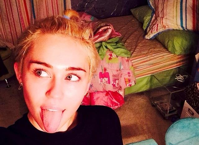 Miley Cyrus in camera da letto con la lingua di fuori