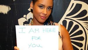 Alicia Keys tiene in mano un cartello della campagna #Wearehere