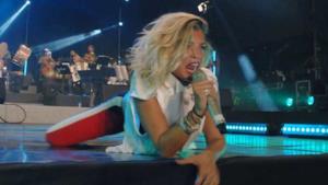 Emma Marrone canta sdraiata sul palco durante un concerto