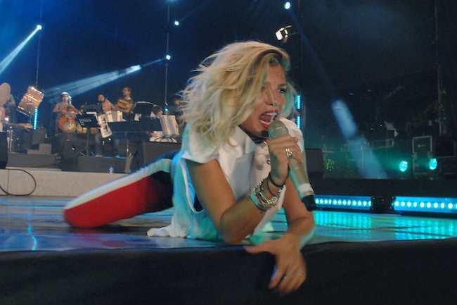 Emma Marrone canta sdraiata sul palco durante un concerto