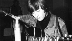 John Lennon con una chitarra acustica in mano