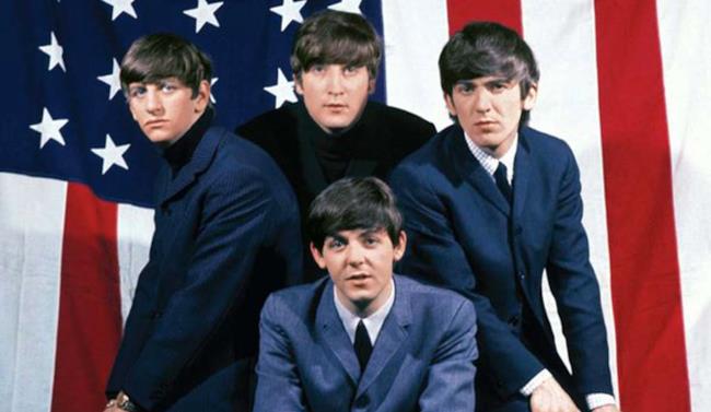 I Beatles nel loro primo arrivo in USA I Beatles posano davanti alla bandiera americana