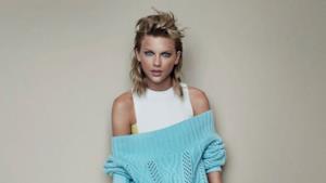 Taylor Swift con canotta bianca e maglione azzurro