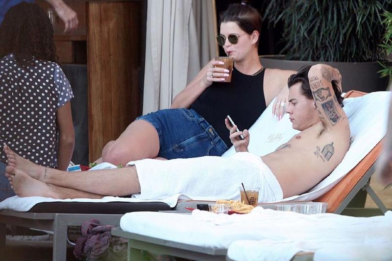 Harry Styles legge i messaggi sul cellulare