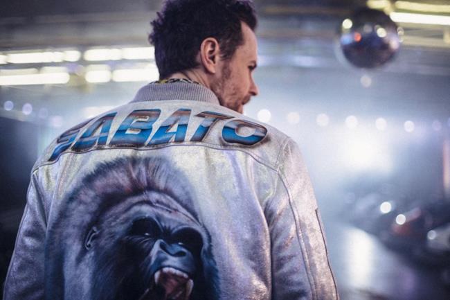 Jovanotti indossa una giacca con la scritta Sabato e un gorilla sulla schiena
