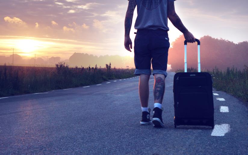 Frasi sulla vita nuova Ragazzo cammina lungo la strada con un trolley