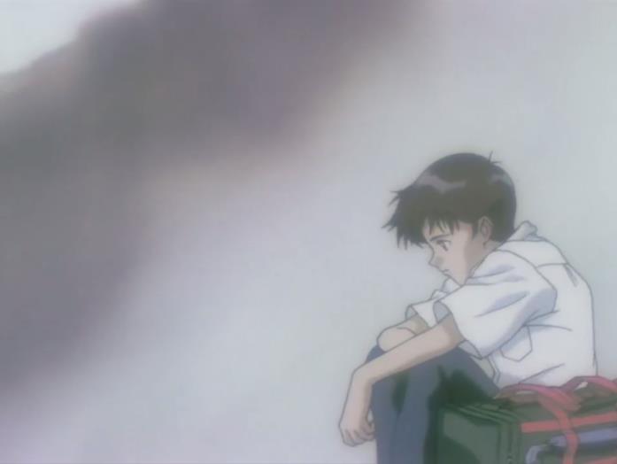 Shinji accovacciato vicino alla sua valigia