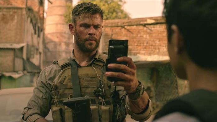 Mezzo primo piano di Chris Hemsworth accovacciato in una scena di Tyler Rake