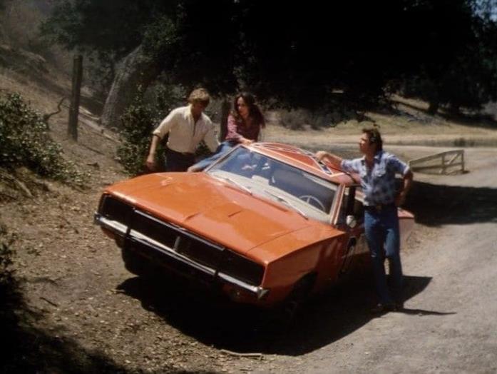 I protagonisti di Hazzard e la mitica auto Hazzard: una scena tratta dalla serie TV