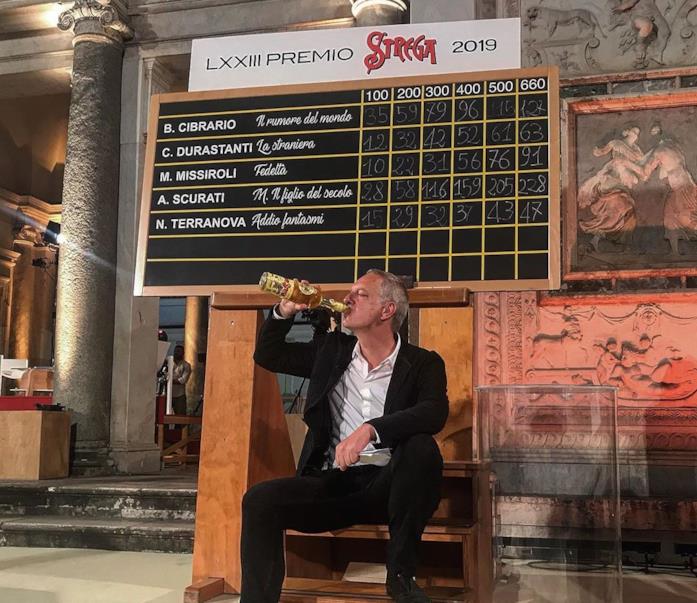 Scurati beva dalla tradizionale bottiglia di Strega