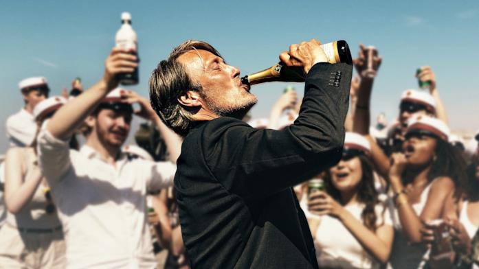 Mads Mikkelsen Martin beve dalla bottiglia insieme ai suoi studenti