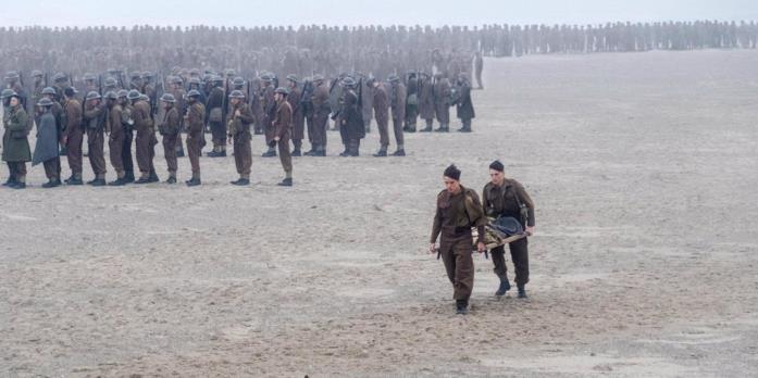 Tommy e Gibson con la barella su spiaggia di Dunkirk Fionn Whitehead e Aneurin Barnard interpretano Tommy e Gibson