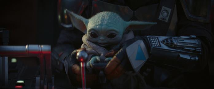 Baby Yoda e Mando in una scena della serie The Mandalorian