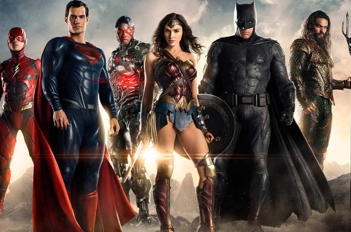 La Justice League in posa, su un terreno brullo e fumoso, con il sole alle spalle