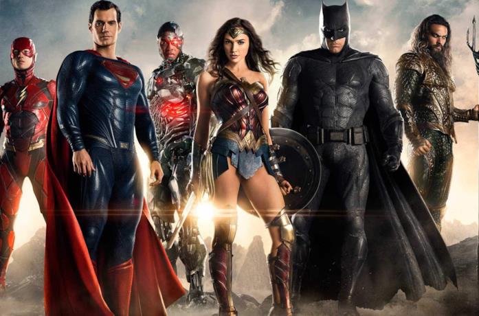 La Justice League in posa, su un terreno brullo e fumoso, con il sole alle spalle