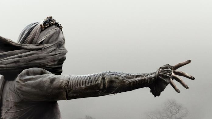 La Llorona La llorona con il braccio teso verso qualcosa, in mezzo alla nebbia