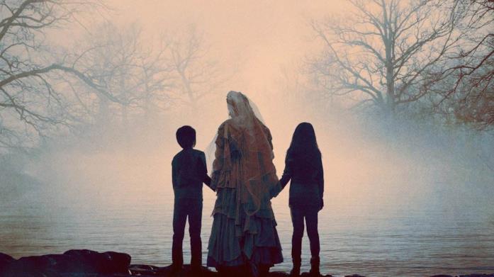 La llorona con due bambini La Llorona, di spalle, conduce un bambino e una bambina verso un lago immerso nella nebbia