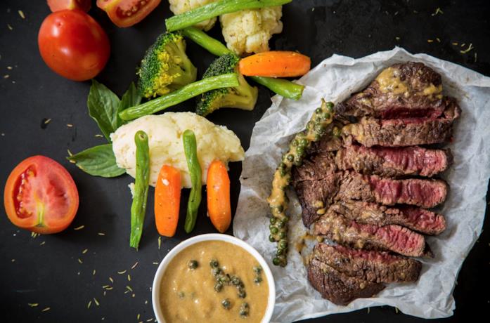 Bistecca e contorno verdure Un piatto di bistecca con verdure