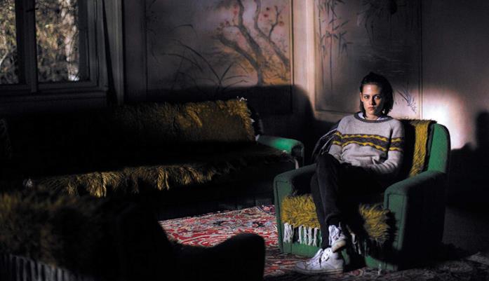 Kristen Stewart parla con gli spiriti in Personal Shopper Kristen Stewart seduta nella penombra della casa infestata in una scena di Personal Shopper