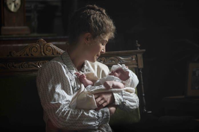 Radioactive: cast e trama del film Marie Curie tiene in braccio la figlia
