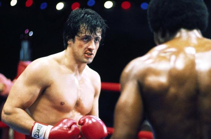 Sylvester Stallone si è ritirato dal casting di Han Solo convinto di non essere adatto Un'immagine che vede Sylvester Stallone nei panni di Rocky Balboa mentre bonxa con Apollo Creed in Rocky