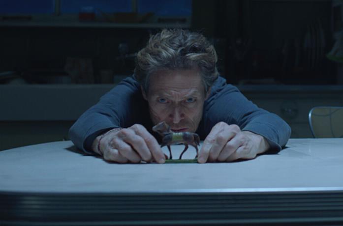 Willem Dafoe osserva un cavallino giocattolo