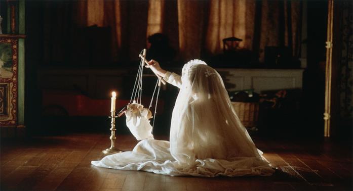 The Others, di Alejandro Amenábar (2001) Una bambina coperta da un velo bianco gioca con una marionetta al lume di candela