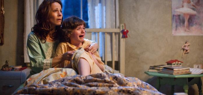 The Conjuring, la vera storia dietro il primo film La signora Perron abbraccia sua figlia impaurita in una scena di The Conjuring