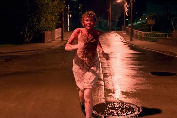 Sydney di I am not okay with this corre per strada, ricoperta di sangue