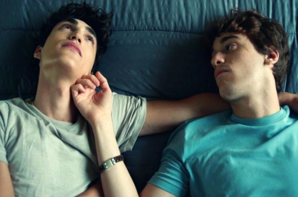 Nico e Martino, i protagonisti della seconda stagione di SKAM, presente su Netflix, sono sdraiati a letto. Nico guarda in alto, Martino osserva il compagno e gli accarezza la guancia