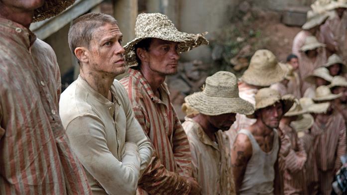 Charlie Hunnam nel ruolo che fu di Steve McQueen Charlie Hunnam con gli altri prigionieri in una scena del film