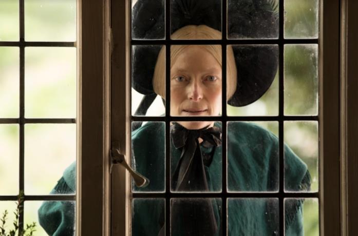 Tilda Swinton spia da una finestra