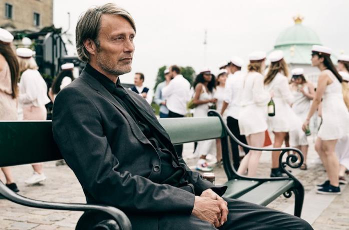 Mads Mikkelsen seduto su una panchina