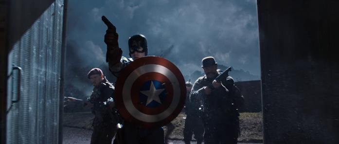 Captain America è il primo Vendicatore Steve Rogers fa irruzione insieme ai suoi compagni in una scena di Captain America - Il primo Vendicatore